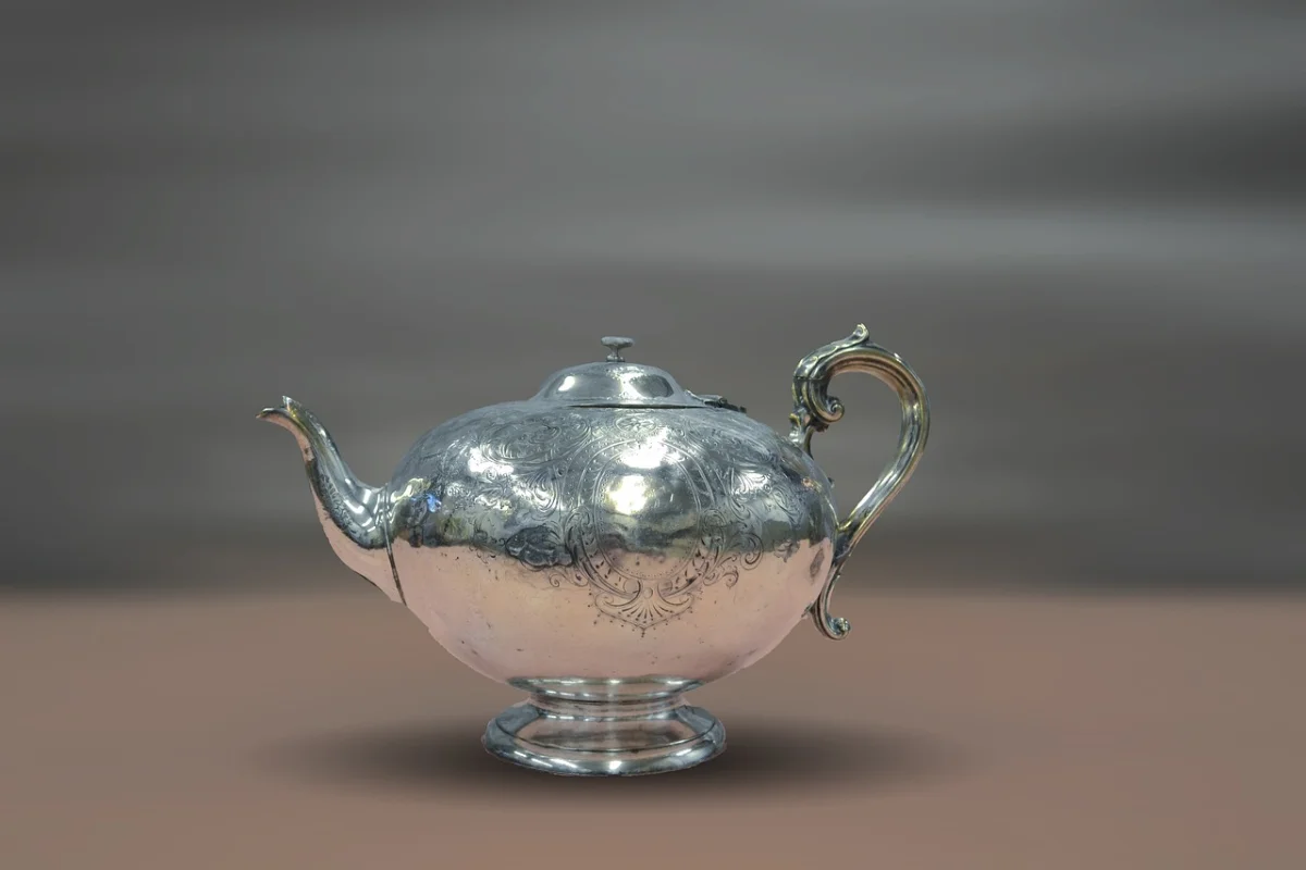 An ornate silver teapot on a neutral background.