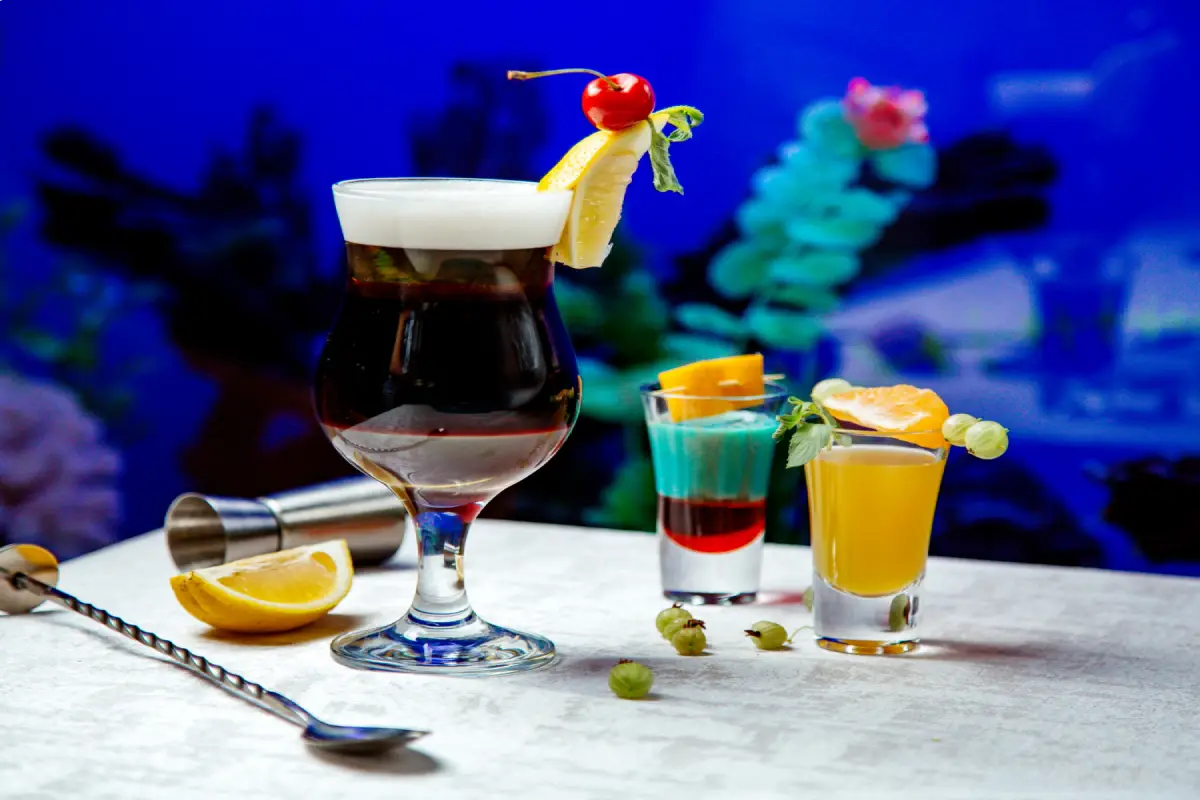 An array of cocktails on a table, each with unique garnishes, symbolizing the drink's cultural journey from classic opera to modern entertainment.