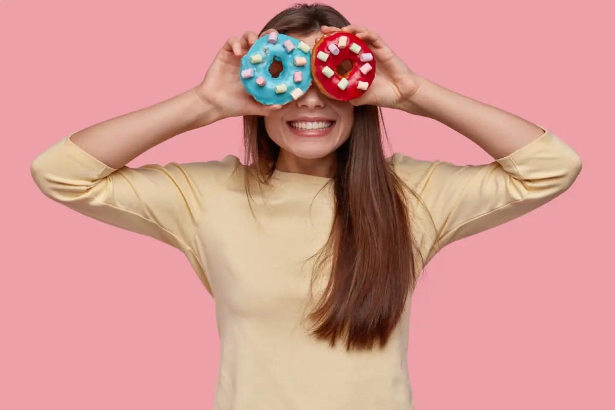 A joyful woman with doughnuts over her eyes, symbolizing fun yet responsible candy consumption