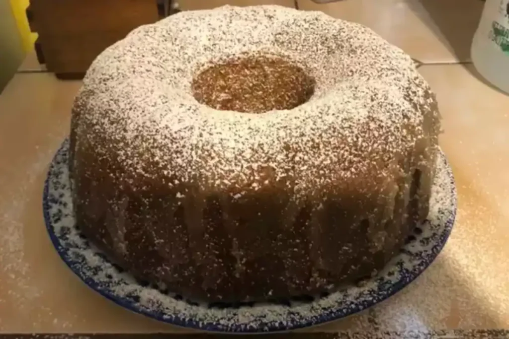 A freshly baked Kentucky Butter Cake dusted with powdered sugar, displayed on a blue and white patterned plate.