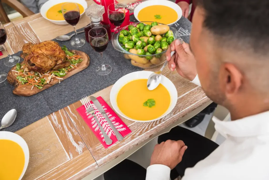 Man enjoying a bowl of rich soup at a festive dining table