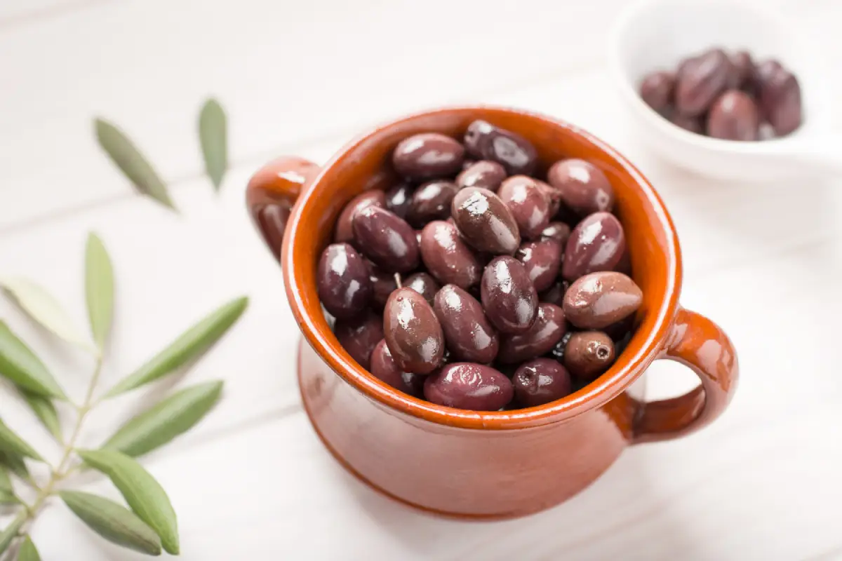A rustic bowl filled with glossy Kalamata olives, symbolizing their rich nutritional profile.