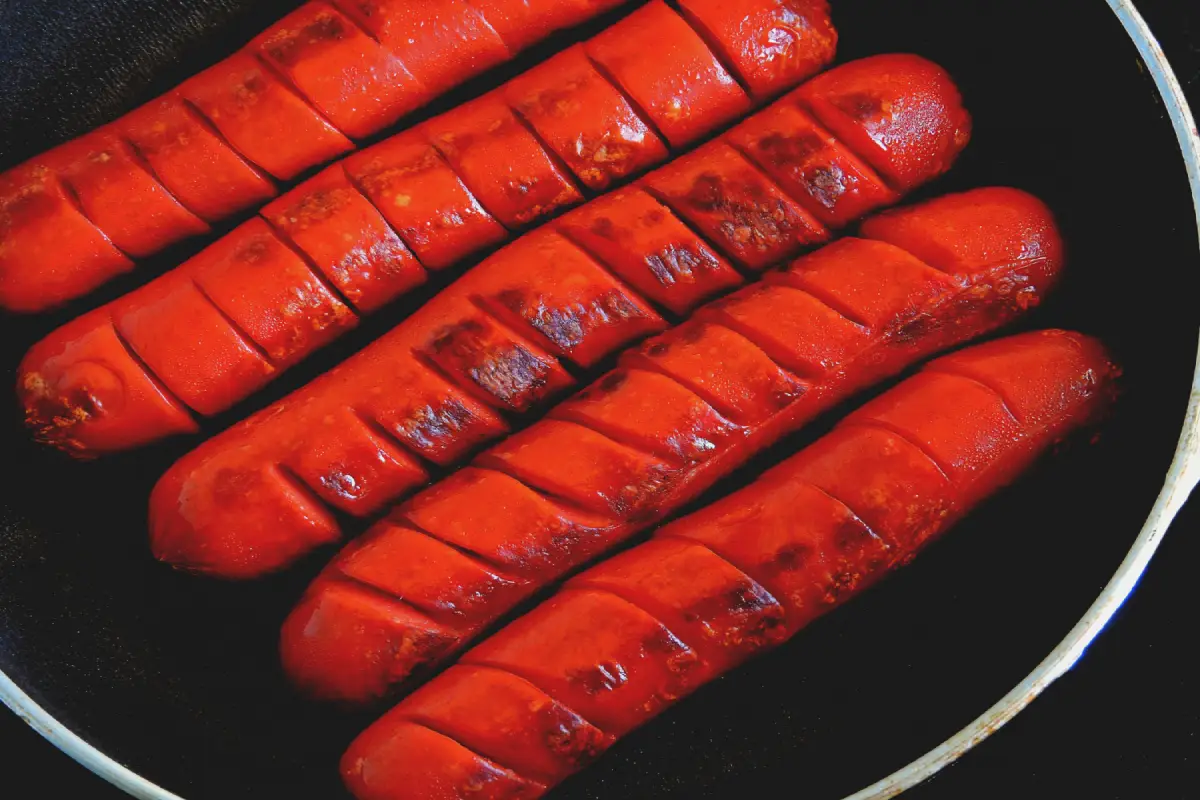 Pan-fried Red Hots sausages showing deep caramelization.