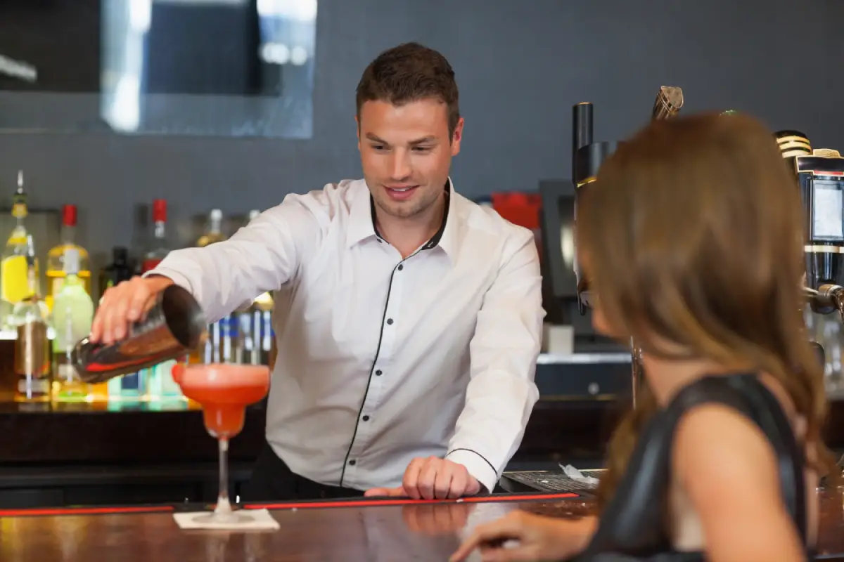 Bartender at TomTom Bar serving a signature cocktail to a guest, showcasing exceptional service and mixology expertise