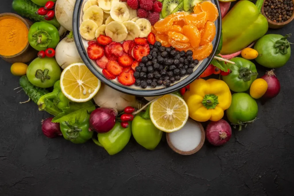 A colorful assortment of fruits perfectly arranged around a bowl of fruit salad, ready to enhance any green salad