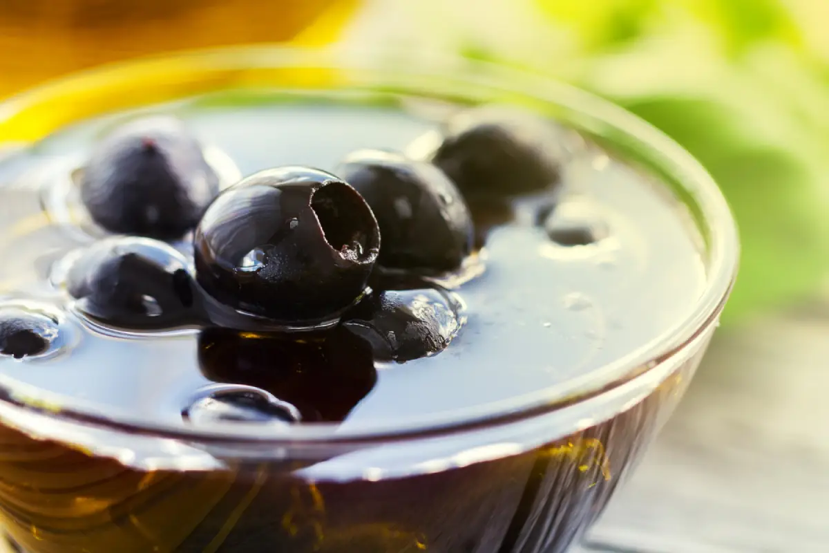 Glistening black olives marinated in olive oil highlighting their antioxidant benefits.
