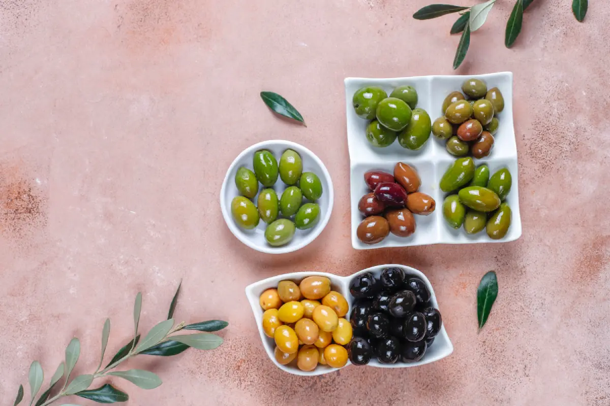 Assorted olives including green, Kalamata, and black varieties on a table
