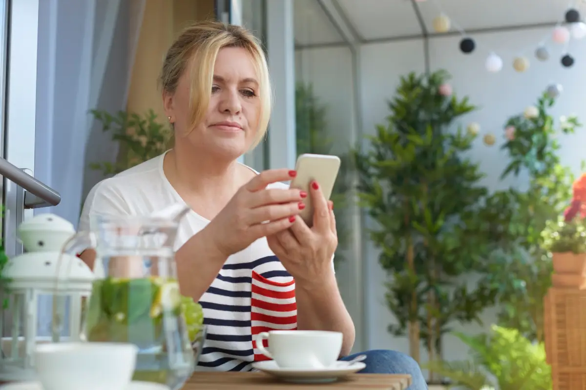 Woman checking caffeine content in Earl Grey tea on her phone