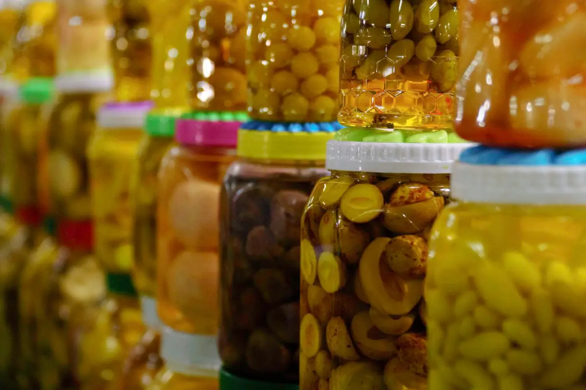 Close-up of jars filled with various types of preserved olives, showcasing the diversity of olive varieties.