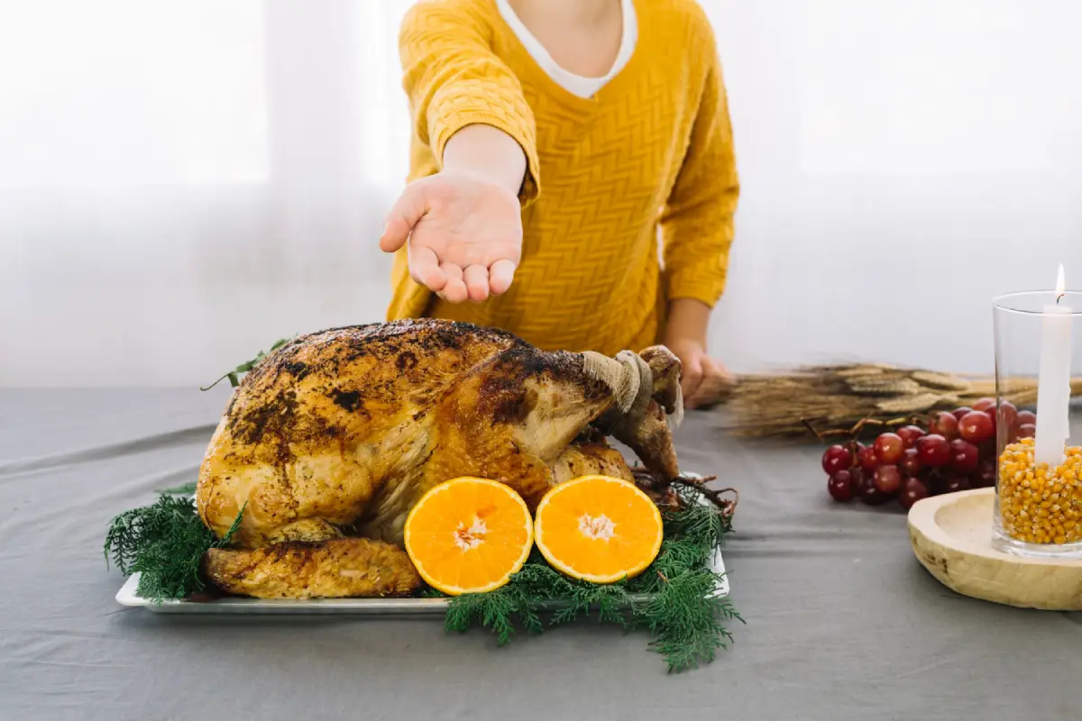 Cook presenting a perfectly basted turkey on a festive table