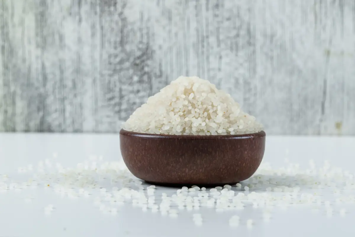 A bowl of round rice on a white grungy background, side view.