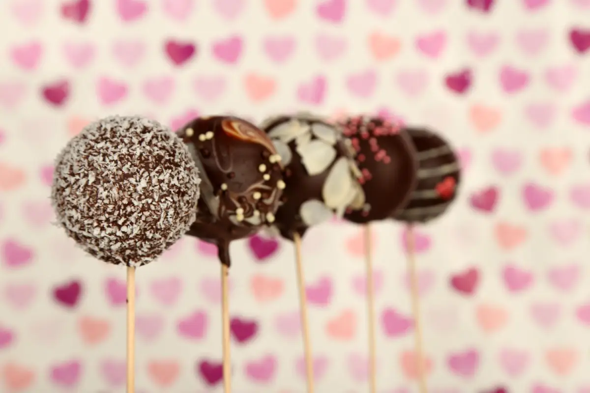 Valentine's Day themed cake pops with a heart-patterned backdrop