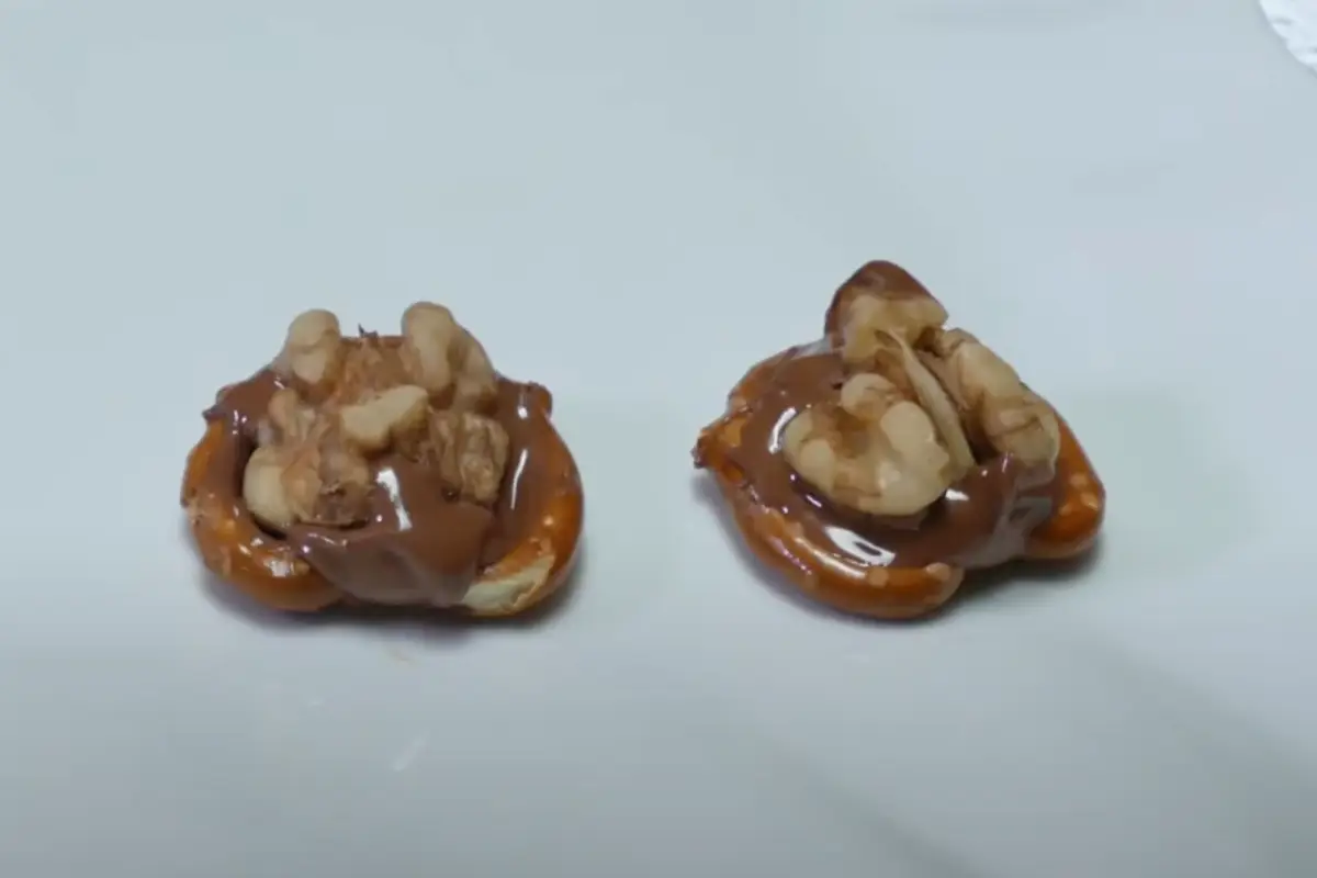 Two completed Rolo Pretzel Bites on a white surface.