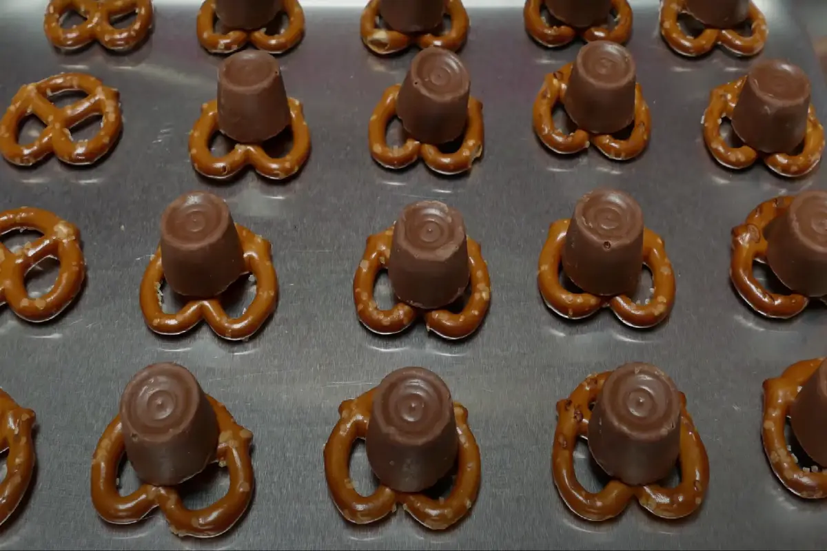 Rolo candies placed on pretzels on a baking sheet, ready to be melted.